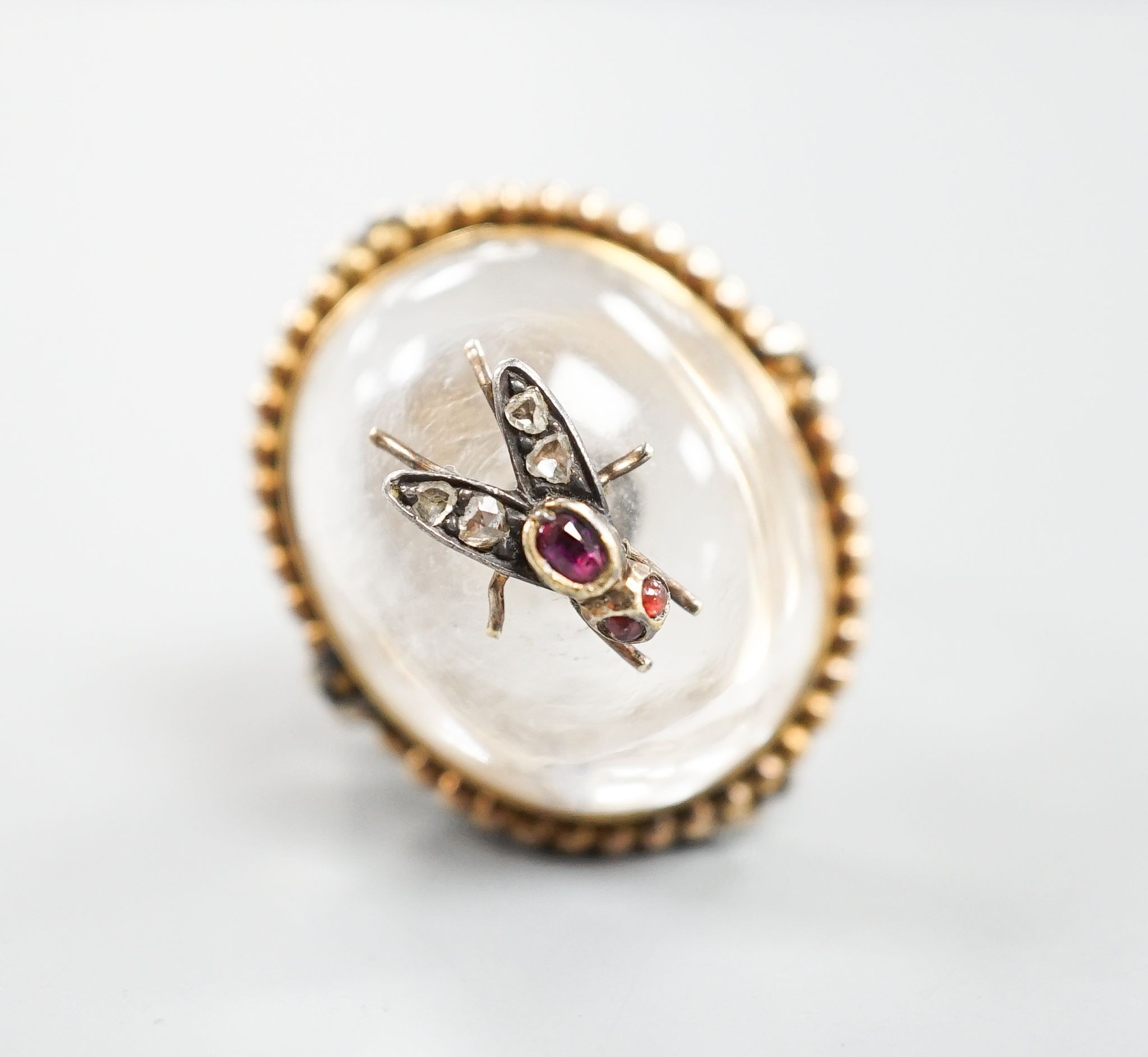 A Victorian, yellow metal and cabochon rock crystal? set dress ring, with central gem set bug motif, size R/S, gross weight 12.4 grams.